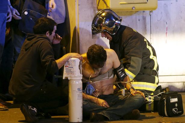 French-fire-brigade-members-aid-an-injured-individual-near-the-Bataclan-concert-hall